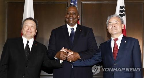 El ministro de Defensa de Corea del Sur, Lee Jong-sup (derecha), el secretario de Defensa de EE. UU., Lloyd Austin (centro), y el ministro de Defensa de Japón, Yasukazu Hamada, se dan la mano antes de sus conversaciones al margen del Diálogo de Shangri-La en Singapur el 3 de junio de 2023. (Pool foto) (Yonhap)