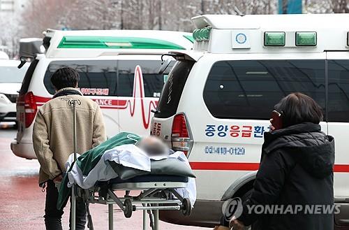 A patient is moved to an ambulance in front of a medical clinic in Seoul to be transferred to another one on Feb. 22, 2024, amid trainee doctors' walkout in protest of the government's plan to raise the medical school enrollment quota. (Yonhap)
