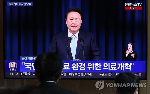 La gente observa el discurso del presidente Yoon Suk Yeol a la nación sobre los planes de reforma médica del gobierno en la Estación de Seúl, Seúl, el 1 de abril de 2024. (Yonhap)