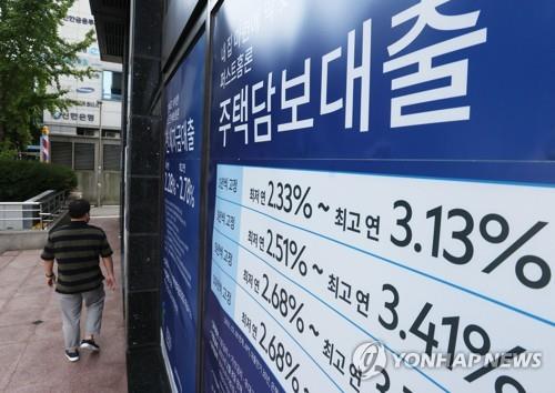 This file photo, taken Oct. 3, 2021, shows signs about a bank's loan programs on the exterior of a lender in Seoul. (Yonhap)