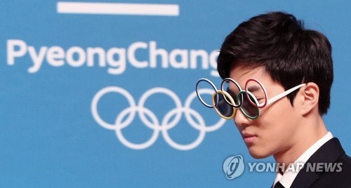 Suho, le leader du groupe EXO, portant des lunettes de soleil en forme d'anneaux olympiques, pose pour une séance photos le mercredi 21 février 2018 lors d'une conférence de presse au centre principal de presse au Alpensia Resort à PyeongChang, dans la province du Gangwon. 