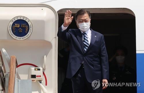 Le président Moon Jae-in salue de la main avant de monter à bord d'un avion en direction de Washington pour tenir un sommet avec le président américain Joe Biden, à l'aéroport de Séoul, dans la province du Gyeonggi, le mercredi 19 mai 2021.
