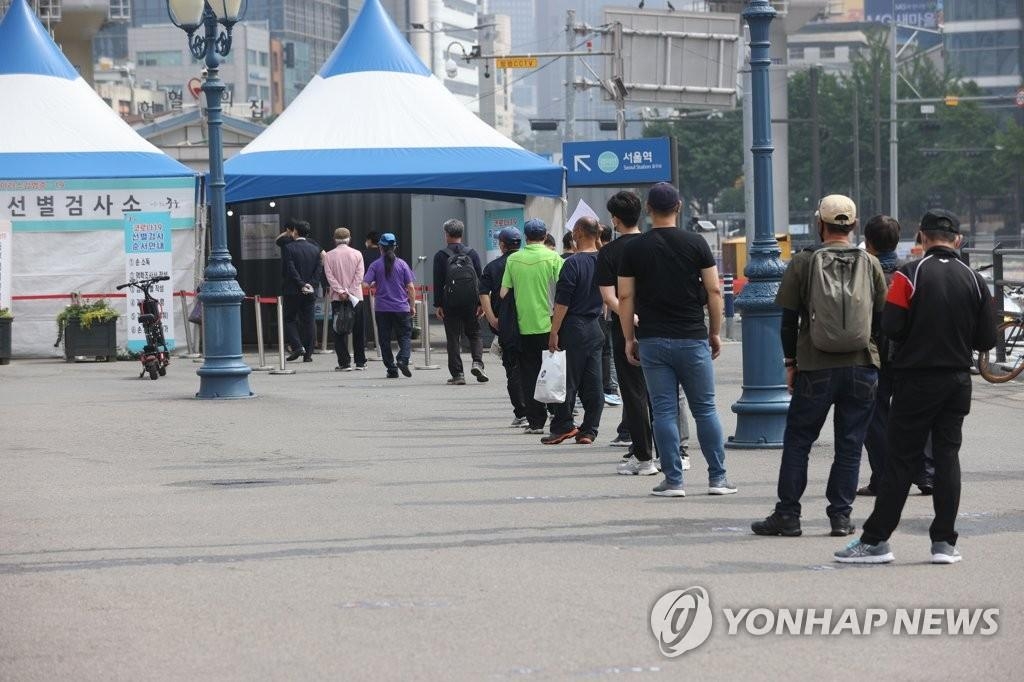 Des personnes font la queue pour recevoir le test de dépistage pour le nouveau coronavirus (Covid-19) dans un centre sur la place de la gare de Séoul le dimanche 6 juin 2021.