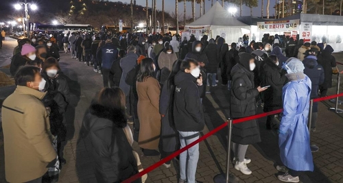 Des gens font la queue devant un centre de dépistage du nouveau coronavirus (Covid-19) installé près du Seoul World Cup Stadium, dans l'ouest de la capitale, le 2 février 2022.