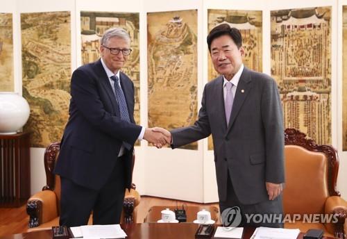 Le président de l'Assemblée nationale Kim Jin-pyo et le cofondateur du géant américain Microsoft Bill Gates échangent une poignée de main durant leur rencontre au Parlement à Séoul, le mardi 16 août 2022. (Pool photo) 