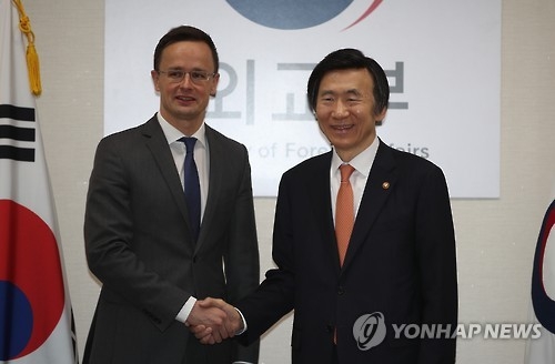 握手を交わす尹長官（右）とシーヤールトー外務貿易相＝１６日、ソウル（聯合ニュース）