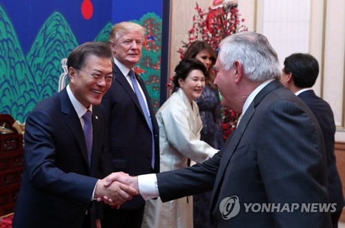 昨年１１月７日、トランプ大統領の訪韓に合わせて青瓦台で開かれた夕食会で握手を交わす文大統領（左）とティラーソン氏＝（聯合ニュース）