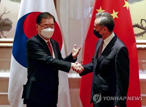 今年４月、韓中外相会談の前に握手を交わす鄭氏（左）と王氏（資料写真）＝（聯合ニュース）
