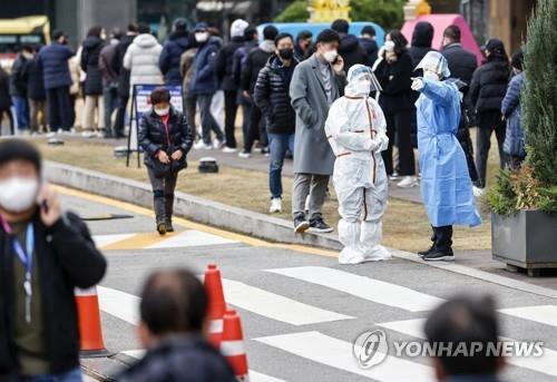 ソウル市内の保健所のそばで新型コロナウイルス検査の順番を待つ人々＝９日、ソウル（聯合ニュース）