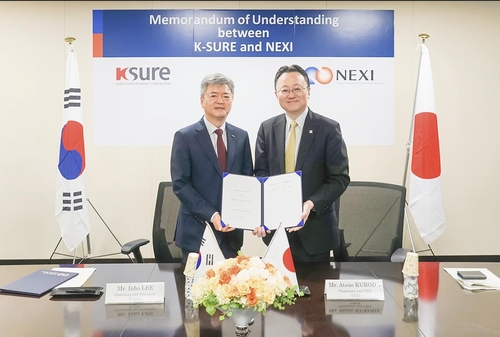 業務協約式に出席した李仁浩（イ・インホ）韓国貿易保険公社社長（左）と黒田篤郎・日本貿易保険社長（韓国貿易保険公社提供）＝（聯合ニュース）≪転載・転用禁止≫
