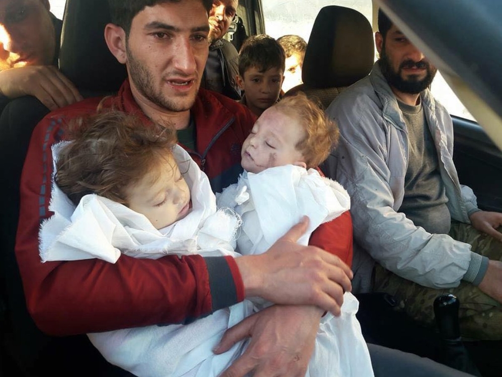 독가스로 죽은 쌍둥이의 시신을 안고 있는 시리아 남성[트위터]