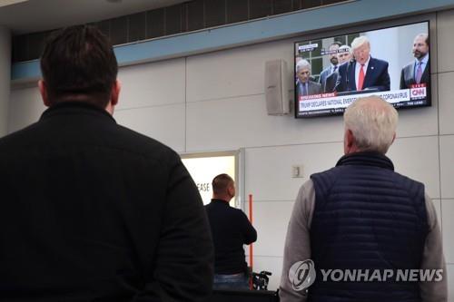 시카고 국제공항에서 트럼프 회견 지켜보는 사람들 [AFP=연합뉴스]