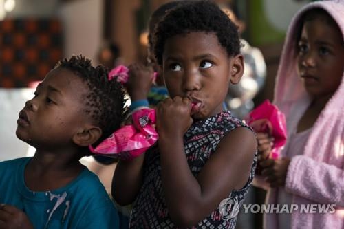 21일 남아공 케이프타운 무허가촌에서 아이들이 아침 '영양팩'을 먹고 있다. 