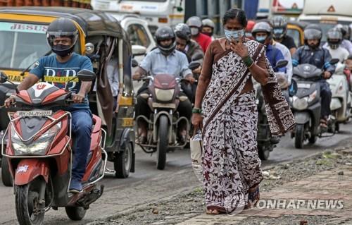 뭄바이 시내에서 마스크를 쓰고 지나가는 주민과 오토바이 운전자. [EPA=연합뉴스]