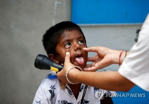 인도 아메다바드에서 의료진으로부터 검사를 받는 어린이. 기사 내용과는 상관없음. [로이터=연합뉴스] 