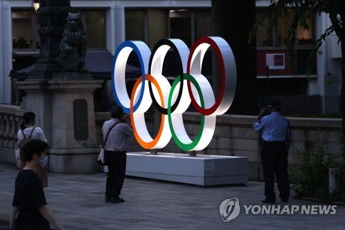 (도쿄=연합뉴스) 이지은 기자 = 도쿄올림픽 개막 8일을 앞둔 15일 오후 일본 도쿄 도심에 설치된 오륜마크 조형물을 한 시민이 사진 찍고 있다. jieunlee@yna.co.kr