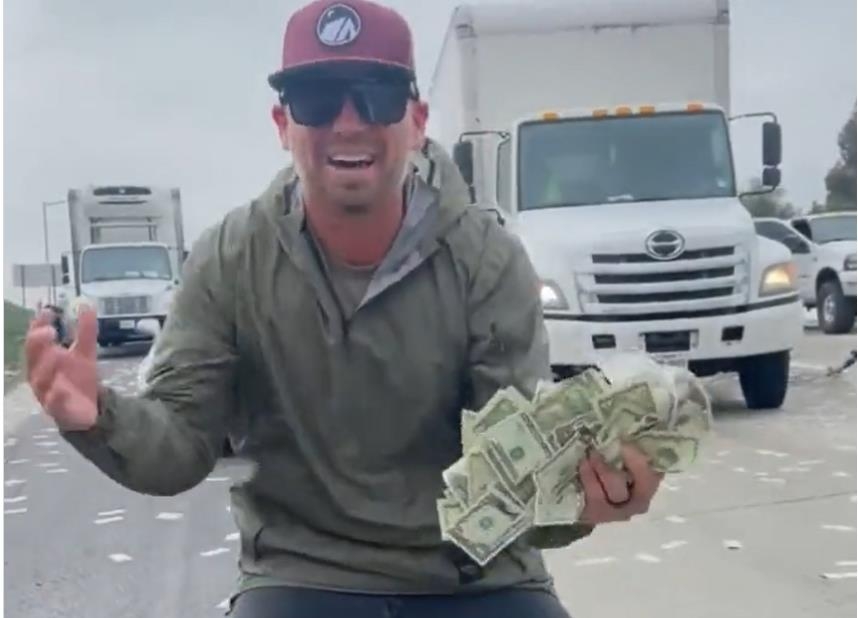 미국 캘리포니아주 고속도로에 뿌려진 연방정부 소유의 돈을 줍고 기뻐하는 남성