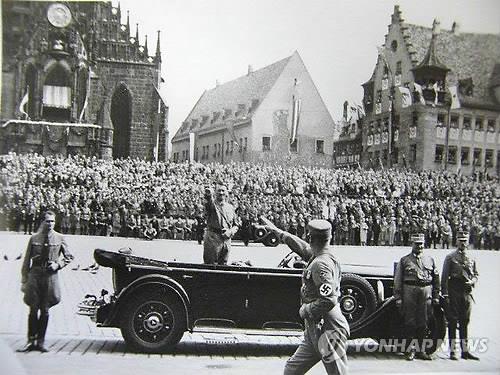 1934년 나치 집회에서 나치식으로 경례하는 히틀러(가운데)