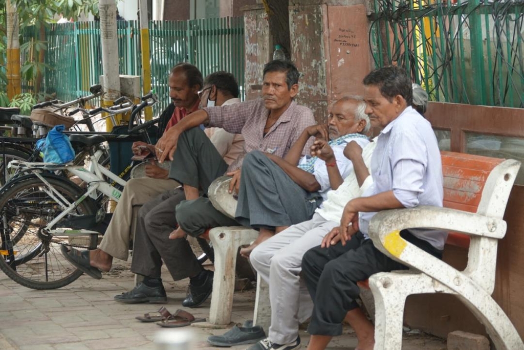 일거리가 없어 멍하니 앉아 있는 인도 뉴델리의 저소득층 