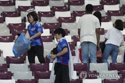 일본이 독일을 꺾은 경기 후 경기장을 청소하는 일본 팬들의 모습.