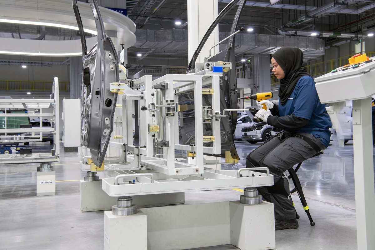 작업자가 의자형 웨어러블 로봇을 이용해 조립하는 모습