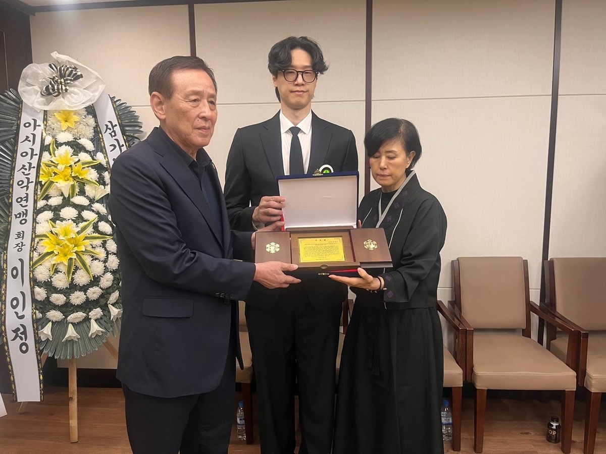 고(故) 장윤창 교수 유족에게 공로패를 전달하는 오한남 대한배구협회장(왼쪽)