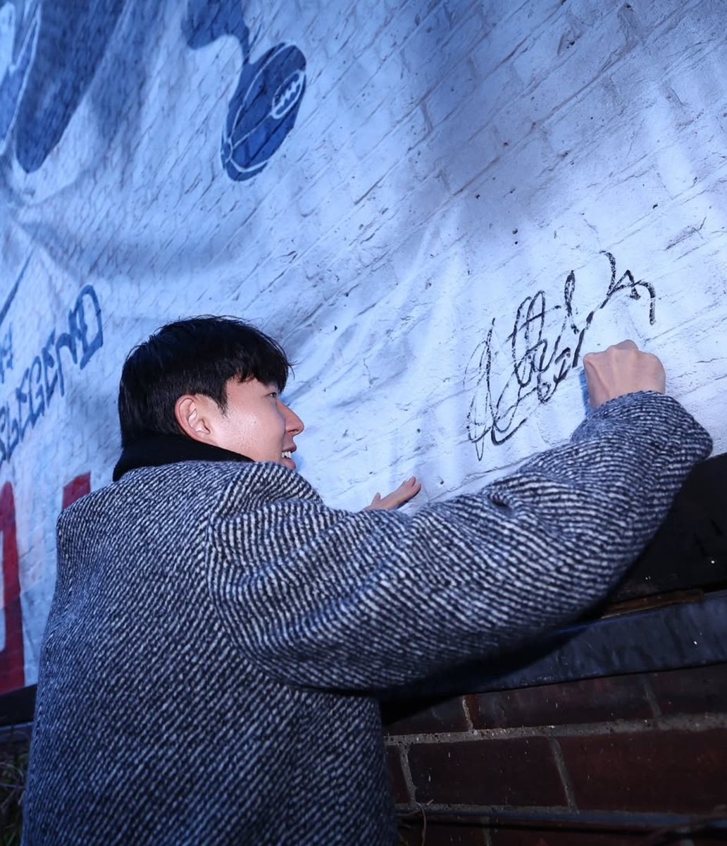 벽화에 서명을 남기는 손흥민