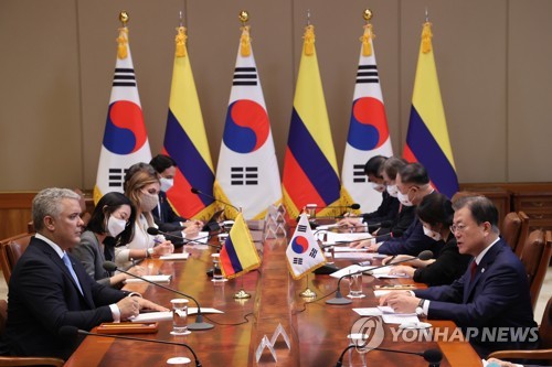 El presidente surcoreano, Moon Jae-in (primero por la dcha.), habla durante una cumbre con el presidente colombiano, Iván Duque Márquez (primero por la izda.), el 25 de agosto de 2021, en la oficina presidencial, Cheong Wa Dae, en Seúl.