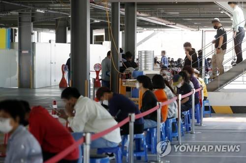 La foto, proporcionada por la oficina del distrito de Buk, en la ciudad suroccidental de Gwangju, muestra a ciudadanos esperando para ser examinados del nuevo coronavirus, el 23 de septiembre de 2021, en una clínica provisional en la oficina, alrededor de 330 kilómetros de Seúl. (Prohibida su reventa y archivo)