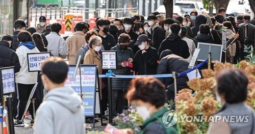 Las personas esperan en fila para someterse a las pruebas del nuevo coronavirus, el 14 de noviembre de 2021, en una clínica provisional, en el oeste de Seúl.