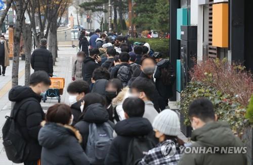 Las personas esperan en fila para someterse a las pruebas del coronavirus, el 29 de noviembre de 2021, en una clínica provisional, en el distrito Songpa, en Seúl. 
