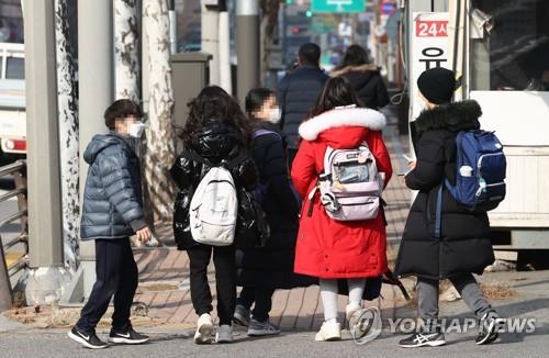 Un grupo de estudiantes de primaria caminan por una calle, el 16 de diciembre de 2021, en Seúl.