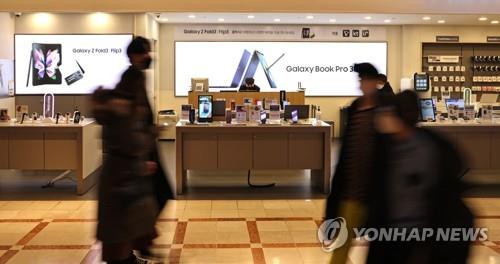 Las personas caminan por una tienda de teléfonos inteligentes de Samsung, el 20 de enero de 2022, en Seúl.