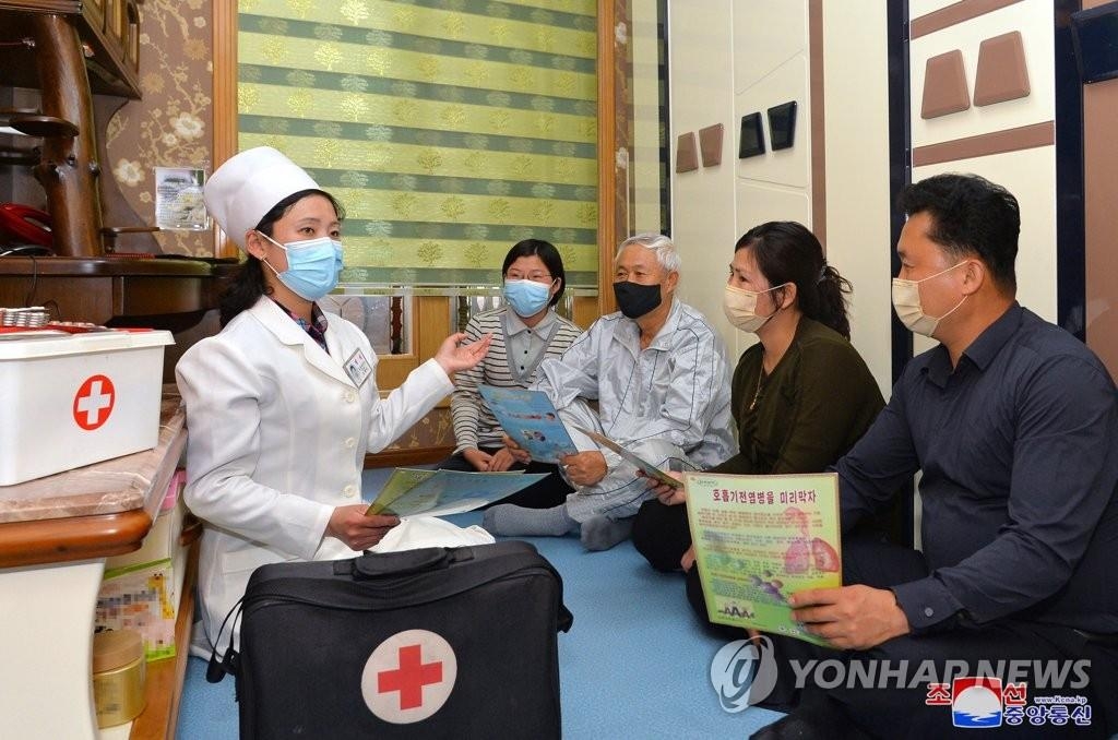 La foto, publicada, el 17 de mayo de 2022, por la KCNA, muestra a una trabajadora médica dando instrucciones a un grupo de personas sobre las prácticas de higiene personal en Pyongyang. (Uso exclusivo dentro de Corea del Sur. Prohibida su distribución parcial o total)
