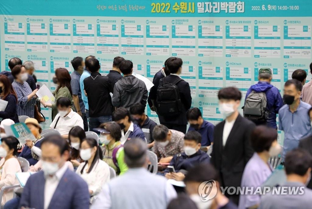 Los demandantes de empleo miran un tablón de anuncios, el 9 de junio de 2022, en una feria de empleo, en Suwon, a unos 30 kilómetros al sur de Seúl.