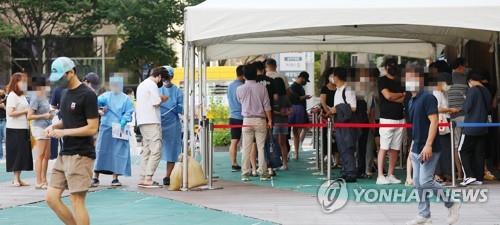 Los ciudadanos esperan en fila para someterse a exámenes de COVID-19, el 16 de agosto de 2022, en una clínica provisional en Seúl.