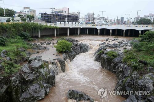La foto, tomada el 5 de septiembre de 2022, muestra un alto nivel de agua en un arroyo en la isla meridional surcoreana de Jeju, mientras el país se prepara para la llegada del tifón "superfuerte" Hinnamnor.