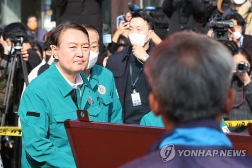El presidente de Corea del Sur, Yoon Suk-yeol (primero por la izda.), visita, el 30 de octubre de 2022, el sitio donde ocurrió una estampida mortal, en Itaewon, durante las celebraciones de Halloween.