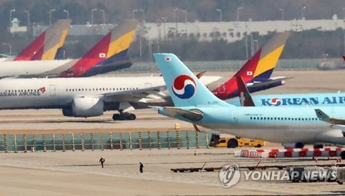 La foto de archivo muestra unos aviones de la aerolínea emblemática surcoreana, Korean Air Co., y de la número dos, Asiana Airlines Inc., aparcados, el 1 de diciembre de 2022, en el Aeropuerto Internacional de Incheon, al oeste de Seúl.