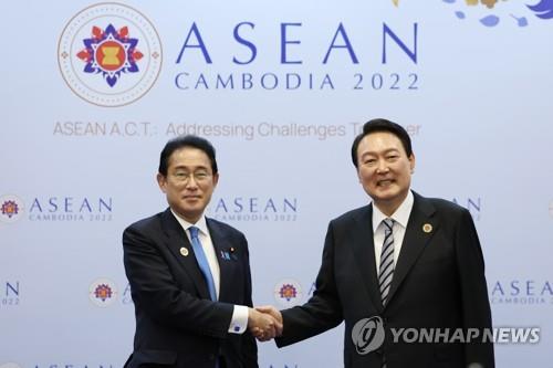 La foto de archivo muestra al presidente surcoreano, Yoon Suk Yeol (dcha.), y el primer ministro japonés, Fumio Kishida, posando ante la cámara, el 13 de noviembre de 2022, antes de iniciar su cumbre bilateral en un hotel de Nom Pen, Camboya.