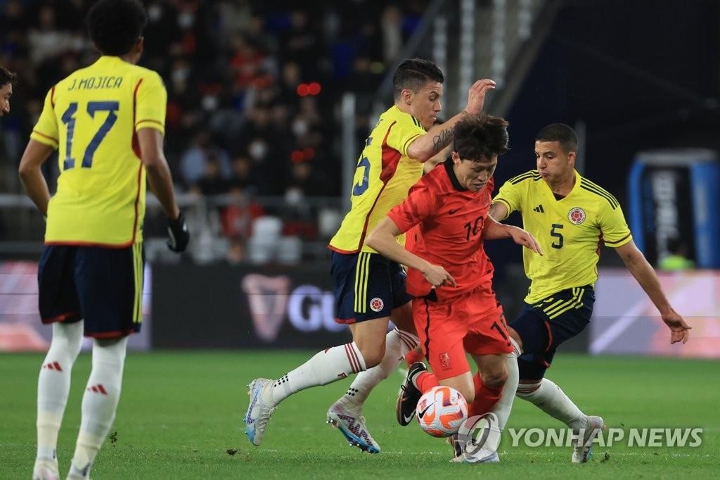 Lee Jae-sung (de rojo), mediocampista de la selección nacional de fútbol de Corea del Sur, avanza con la pelota entre los jugadores rivales, el 24 de marzo de 2023, en el estadio de fútbol Munsu, en la ciudad suroriental de Ulsan. 