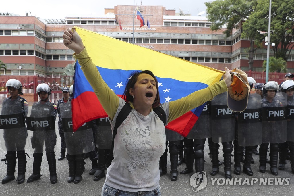 베네수엘라 해군 청사 앞에서 국기를 펼쳐들고 항의하는 야권 지지자 [AP=연합뉴스 자료 사진]