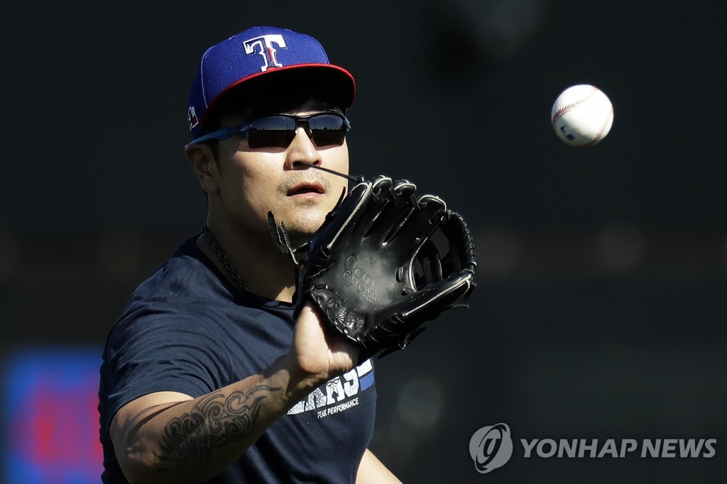 In this Associated Press file photo from Feb. 14, 2020, Choo Shin-soo of the Texas Rangers plays catch during his club's spring training at Surprise Stadium in Surprise, Arizona. (Yonhap)