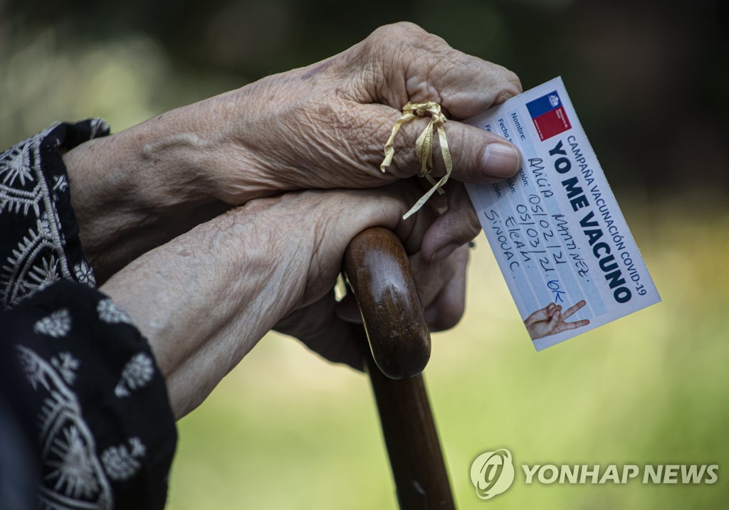 코로나19 백신 접종 확인서를 들고 있는 칠레 노인