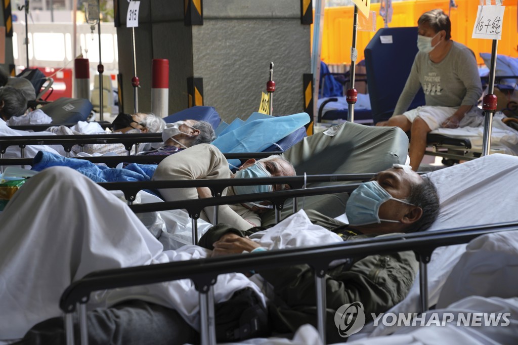 (AP=연합뉴스) 지난 2일 홍콩 카리타스 메디컬센터의 바깥에서 코로나19 환자들이 침대에 누운 채 대기하는 모습. 2022.3.3.