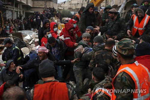 무너진 건물서 생존자 옮기는 시리아인들