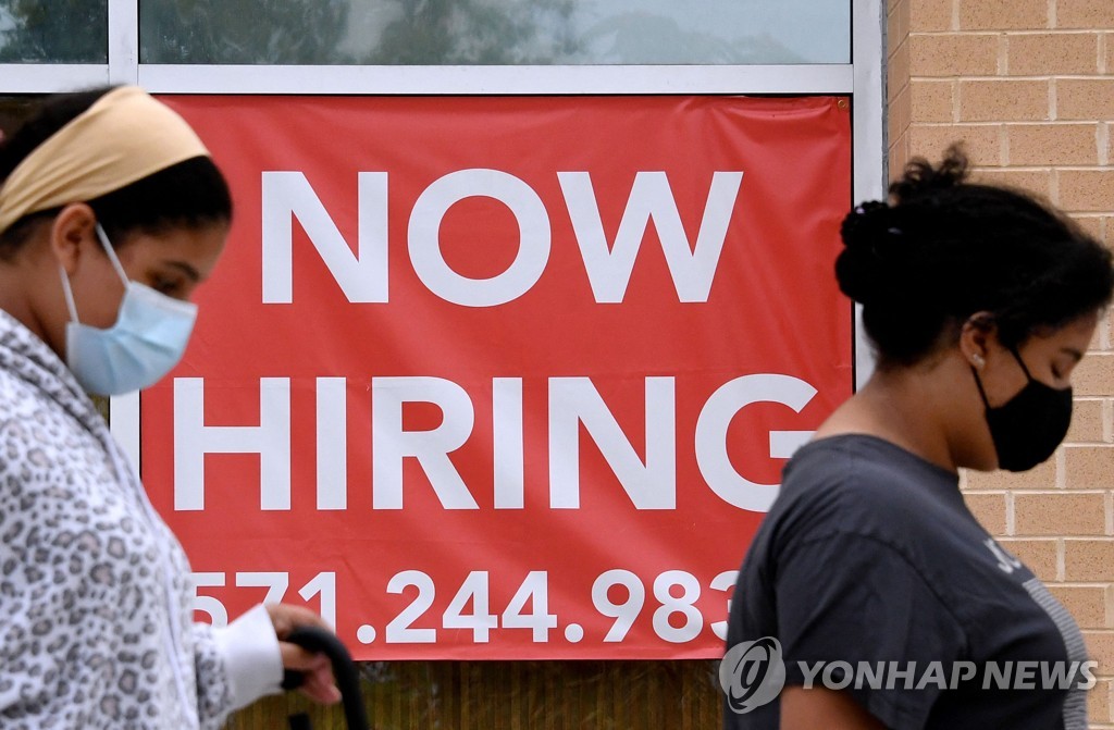 채용공고를 붙인 미국 버지니아주 알링턴의 한 상점 앞을 지나는 여성들