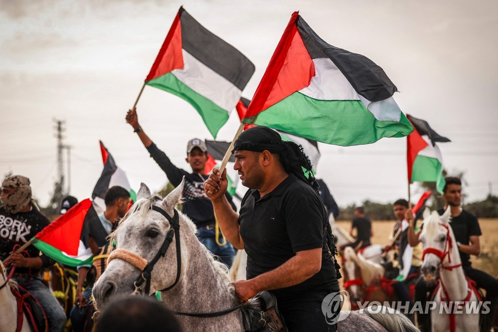 74주년 '나크바(대재앙)의 날' 행사에서 팔레스타인 깃발을 흔드는 팔레스타인 주민들.