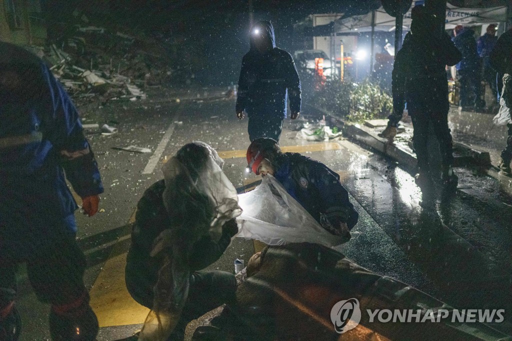 튀르키예에서 악천후 속 부상자를 돕고 있는 구조대원들 [AFP=연합뉴스]