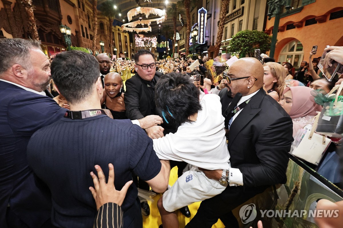 지난 13일 싱가포르 행사에서 물의를 일으키고 끌려가는 존슨 웬